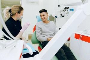 dental patient sitting in procedure chair smiling at doctor