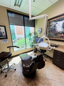 Modern dental treatment room with chair and equipment.